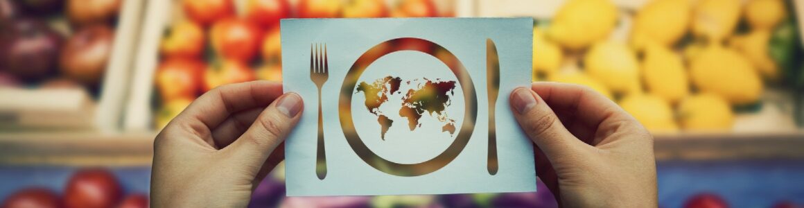 A picture of silverware and a plate with the worlds geography representing the global food system.